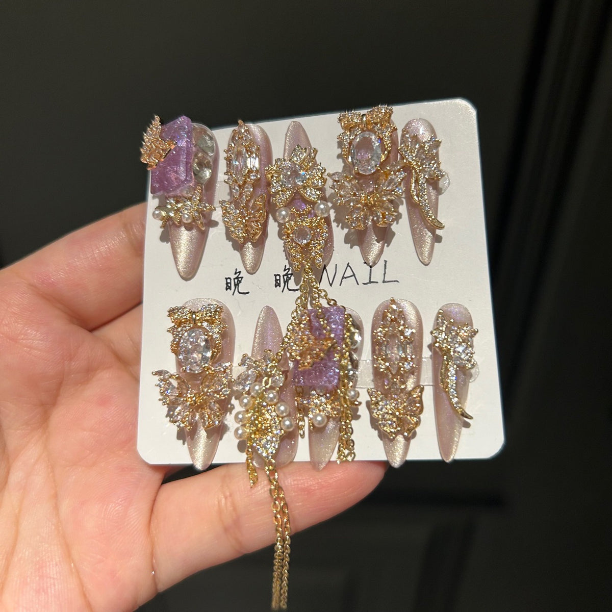 Champagne Pink & Purple Cat Eye Stiletto Press-on Nails with Purple Crystal Gem, Gold Rhinestone Bow, and Interlinked Hanging Chain - Luxury Glam Fake Nail Set