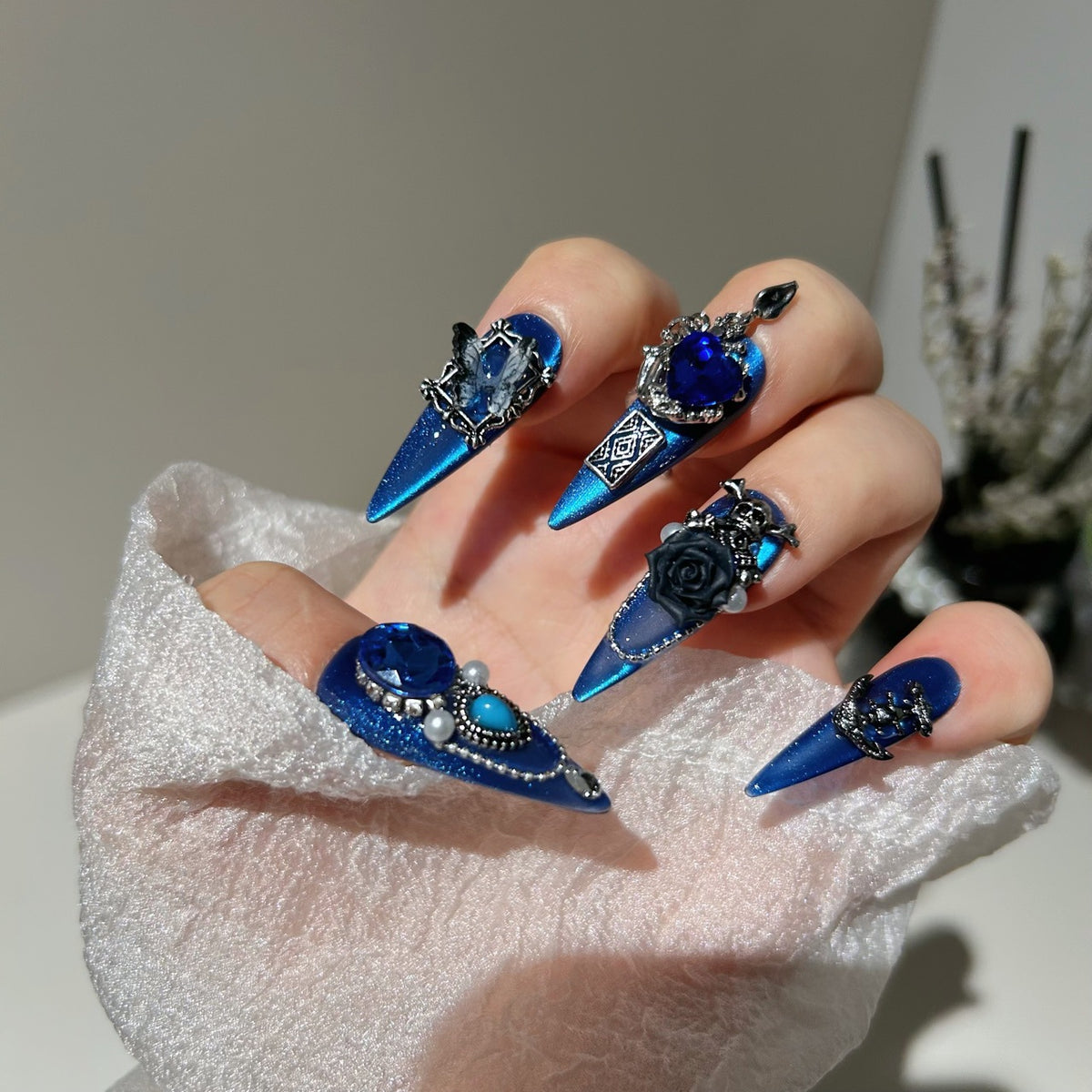 Royal Blue Cat Eye Stiletto Press-on Nails with Oversized Blue Crystals, 3D Black Rose, Skull, Vintage Frame, and Interlinked Chain - Gothic Cyber Fake Nail Set