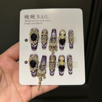 Handmade Purple Cat Eye Long Coffin Press On Nails. Dark royal gothic false nails decorated with large black heart & oval gems, vintage gold crown and cross charms, pearls, gold rhinestones and dangling gold chains