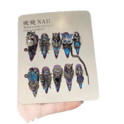 Handmade Blue Purple Cat Eye Long Stiletto Press On Nails. Dark gothic false nails decorated with 3D silver skull, butterfly & cross charms, heart gems, pearls and dangling metal chains. Reusable fake nails for parties, cosplay and Halloween.