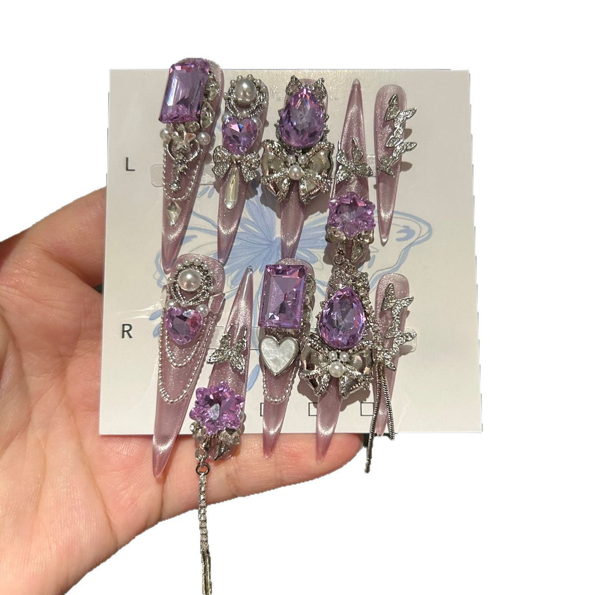 Handmade Milky Pink Metallic Long Stiletto Press On Nails with Large Purple Crystals, Rhinestone Bows, Butterfly Charms, Pearls & Dangling Chains