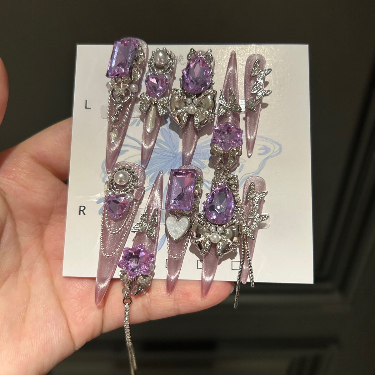 Handmade Milky Pink Metallic Long Stiletto Press On Nails with Large Purple Crystals, Rhinestone Bows, Butterfly Charms, Pearls & Dangling Chains