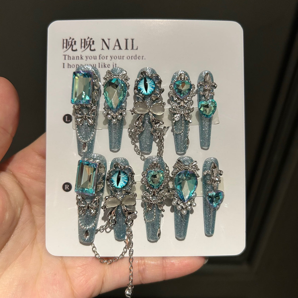 Icy Blue Cat Eye Coffin Press-on Nails with Oversized Iridescent Crystals, 3D Evil Eye, Bow, and Interlinked Chain - Y2K Cyber Glam Fake Nail Set