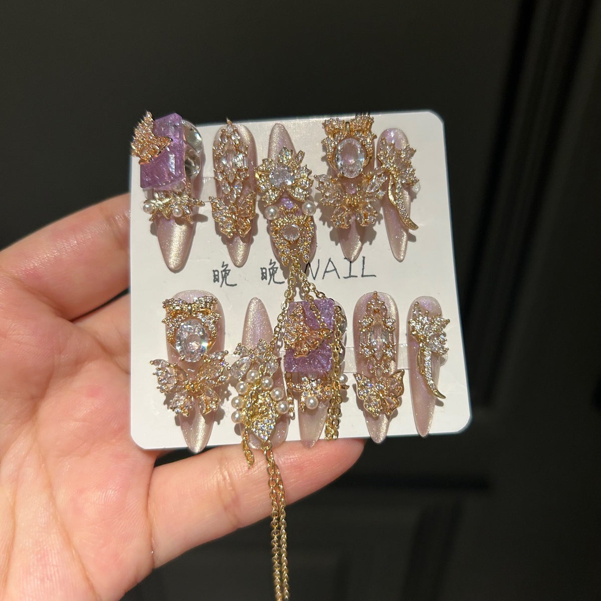 Champagne Pink & Purple Cat Eye Stiletto Press-on Nails with Purple Crystal Gem, Gold Rhinestone Bow, and Interlinked Hanging Chain - Luxury Glam Fake Nail Set