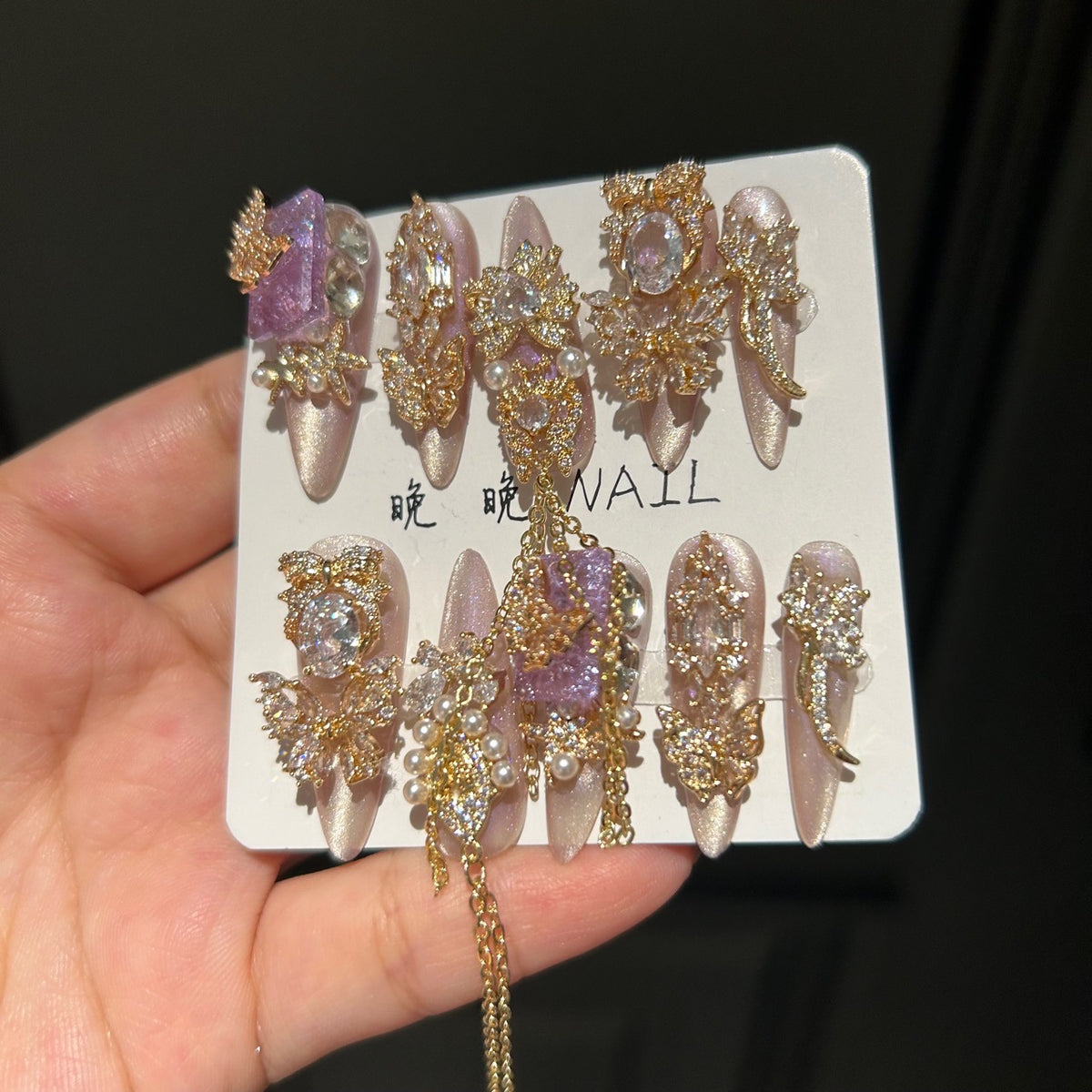 Champagne Pink & Purple Cat Eye Stiletto Press-on Nails with Purple Crystal Gem, Gold Rhinestone Bow, and Interlinked Hanging Chain - Luxury Glam Fake Nail Set