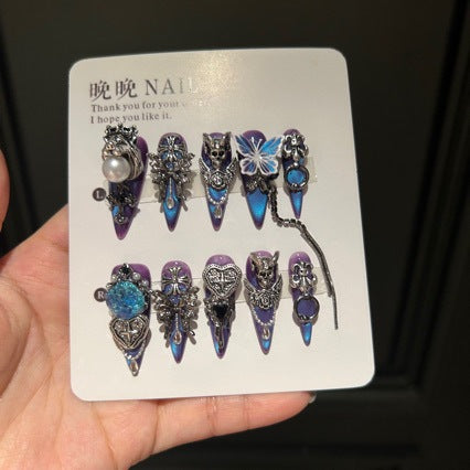 Handmade Blue Purple Cat Eye Long Stiletto Press On Nails. Dark gothic false nails decorated with 3D silver skull, butterfly & cross charms, heart gems, pearls and dangling metal chains. Reusable fake nails for parties, cosplay and Halloween.