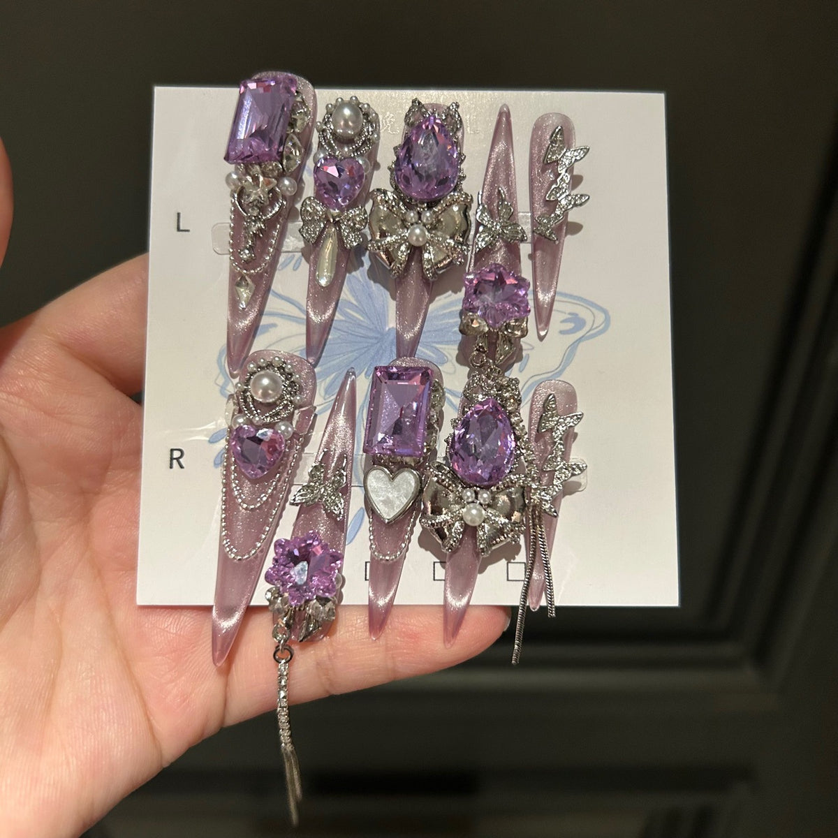 Handmade Milky Pink Metallic Long Stiletto Press On Nails with Large Purple Crystals, Rhinestone Bows, Butterfly Charms, Pearls & Dangling Chains