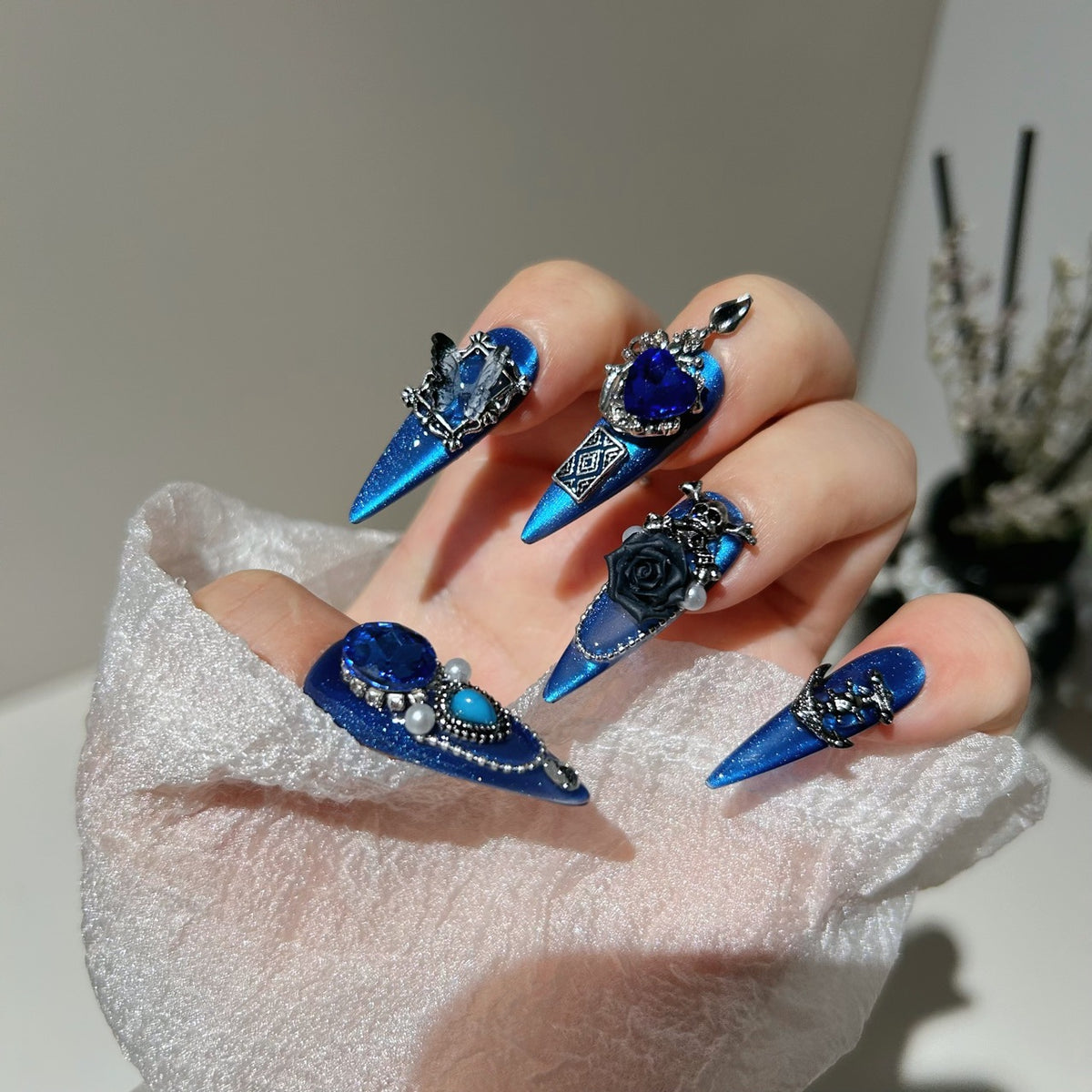 Royal Blue Cat Eye Stiletto Press-on Nails with Oversized Blue Crystals, 3D Black Rose, Skull, Vintage Frame, and Interlinked Chain - Gothic Cyber Fake Nail Set