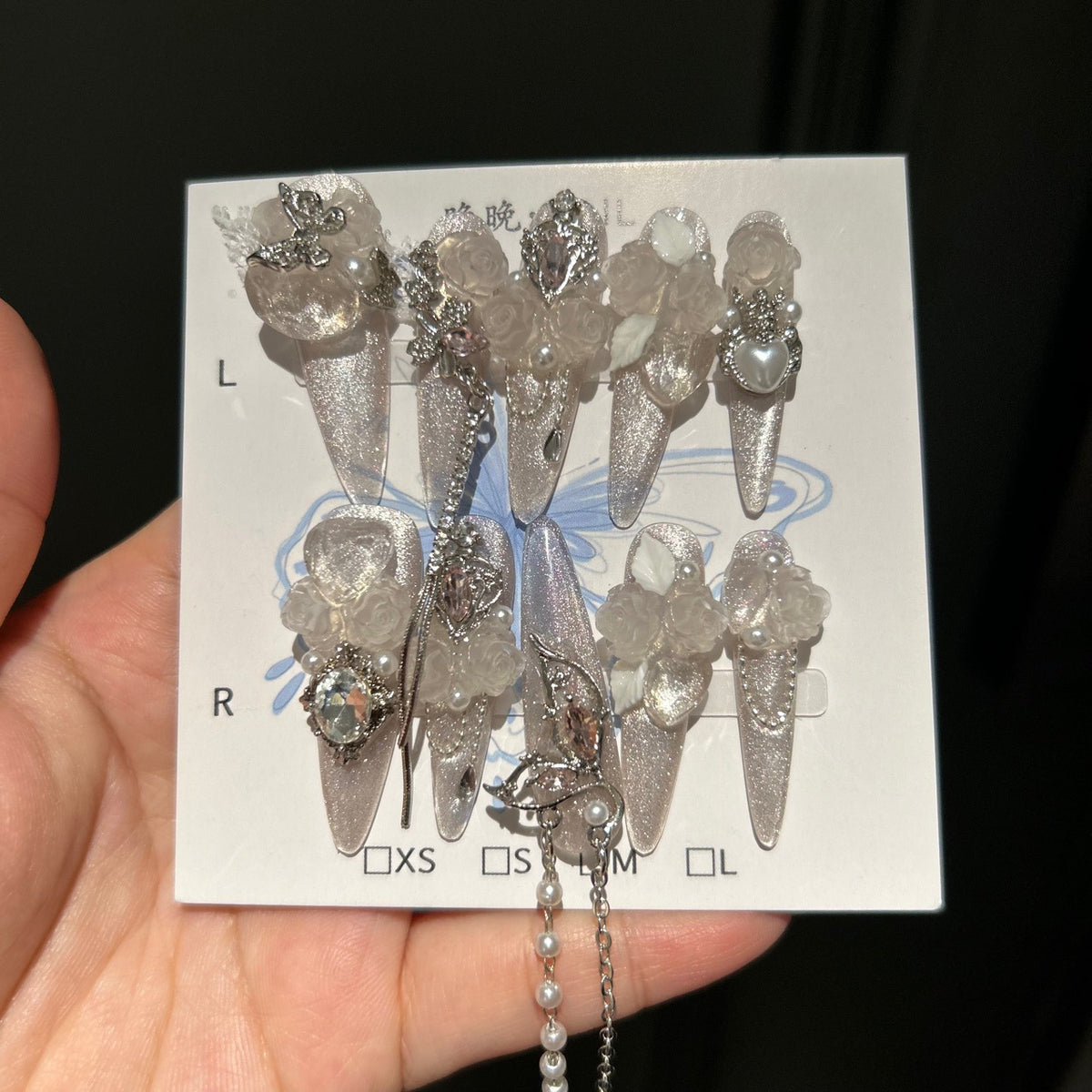 Handmade Milky Silver Cat Eye Long Stiletto Press On Nails with Frosted 3D White Roses, Butterfly Charms, Heart Crystals & Pearl Chain Tassels