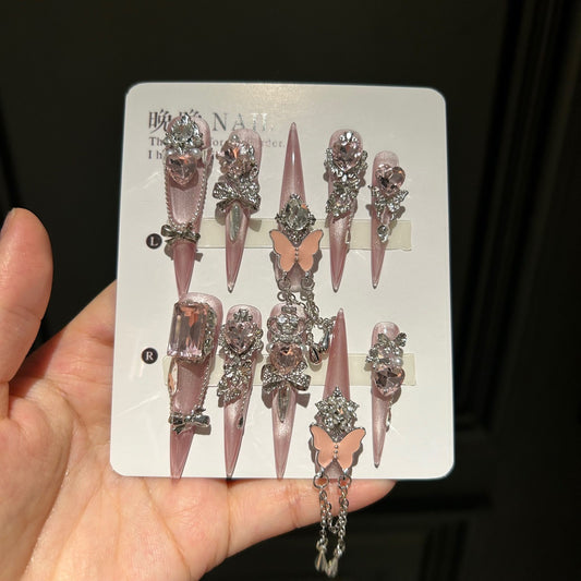 Handmade Soft Nude Pink Press On Nails, Long Stiletto Princess False Nails with Pink Heart Rhinestones, 3D Butterfly, Silver Bow Charms, Pearls & Dangling Silver Chain, Reusable Fake Nails for Wedding & Party