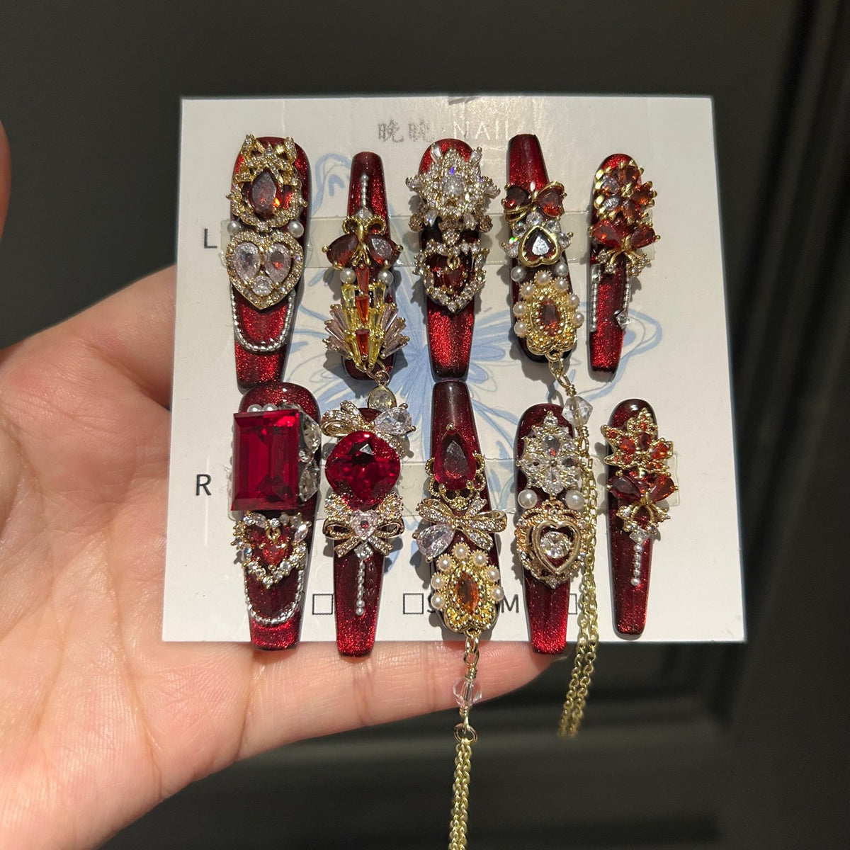 Handcrafted Designer Ruby Press-on Nails - Shimmering Cat Eye Base with Heavy 3D Red Gemstones, Gold Filigree and Chain Drops