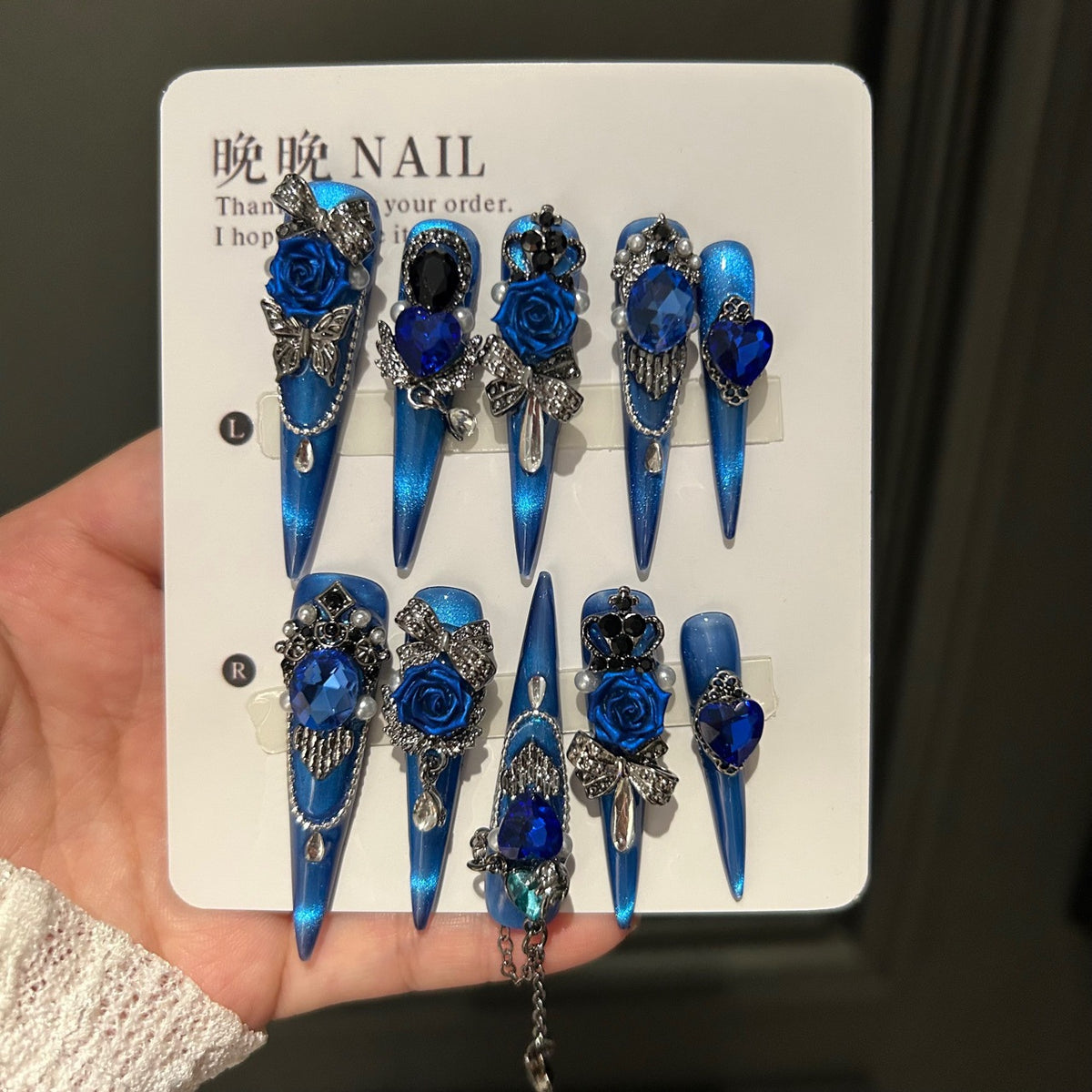 Handmade Electric Blue Cat Eye Long Stiletto Press On Nails with 3D Blue Roses, Giant Blue Heart Crystals, Rhinestone Crowns, Butterfly Charms & Dangling Chains