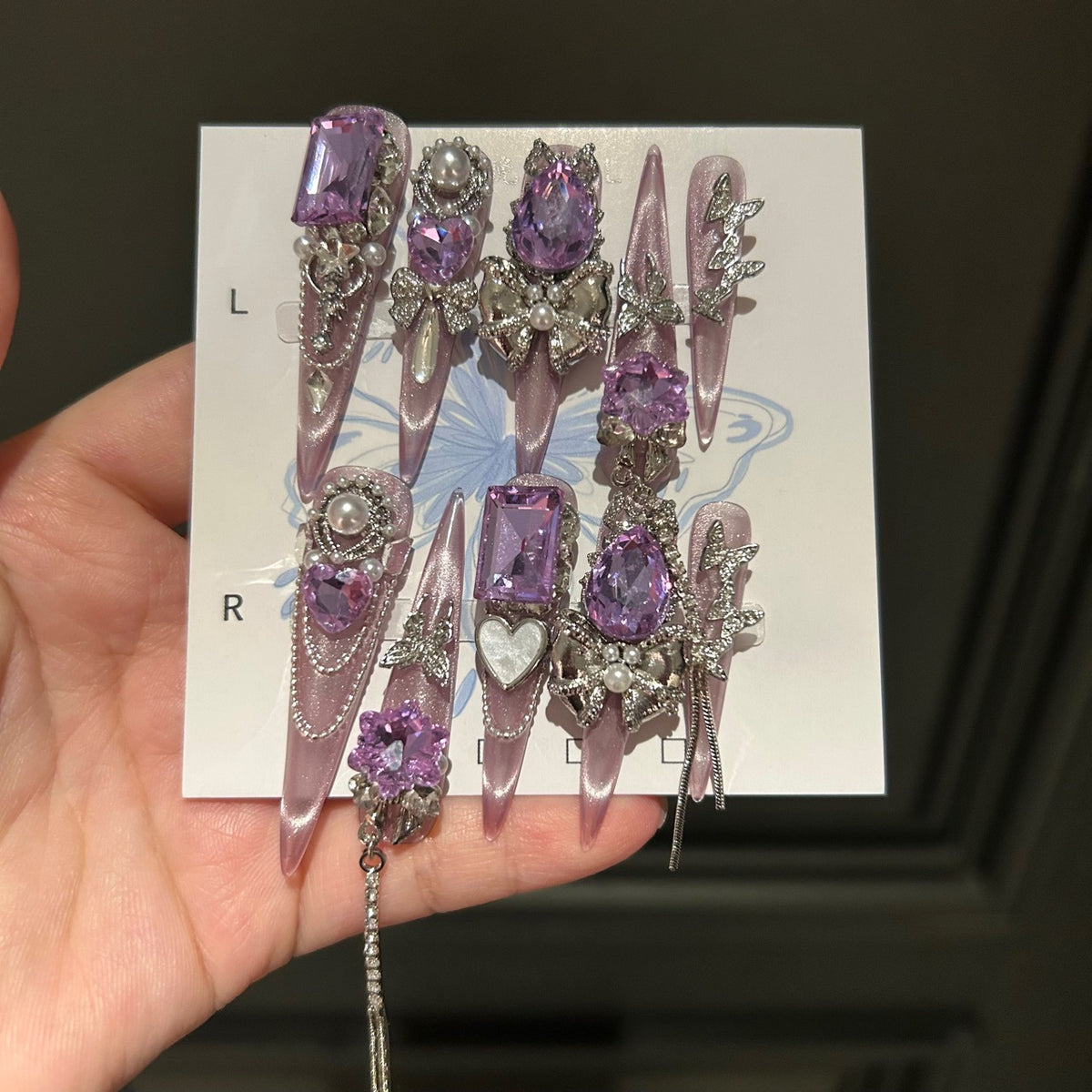 Handmade Milky Pink Metallic Long Stiletto Press On Nails with Large Purple Crystals, Rhinestone Bows, Butterfly Charms, Pearls & Dangling Chains