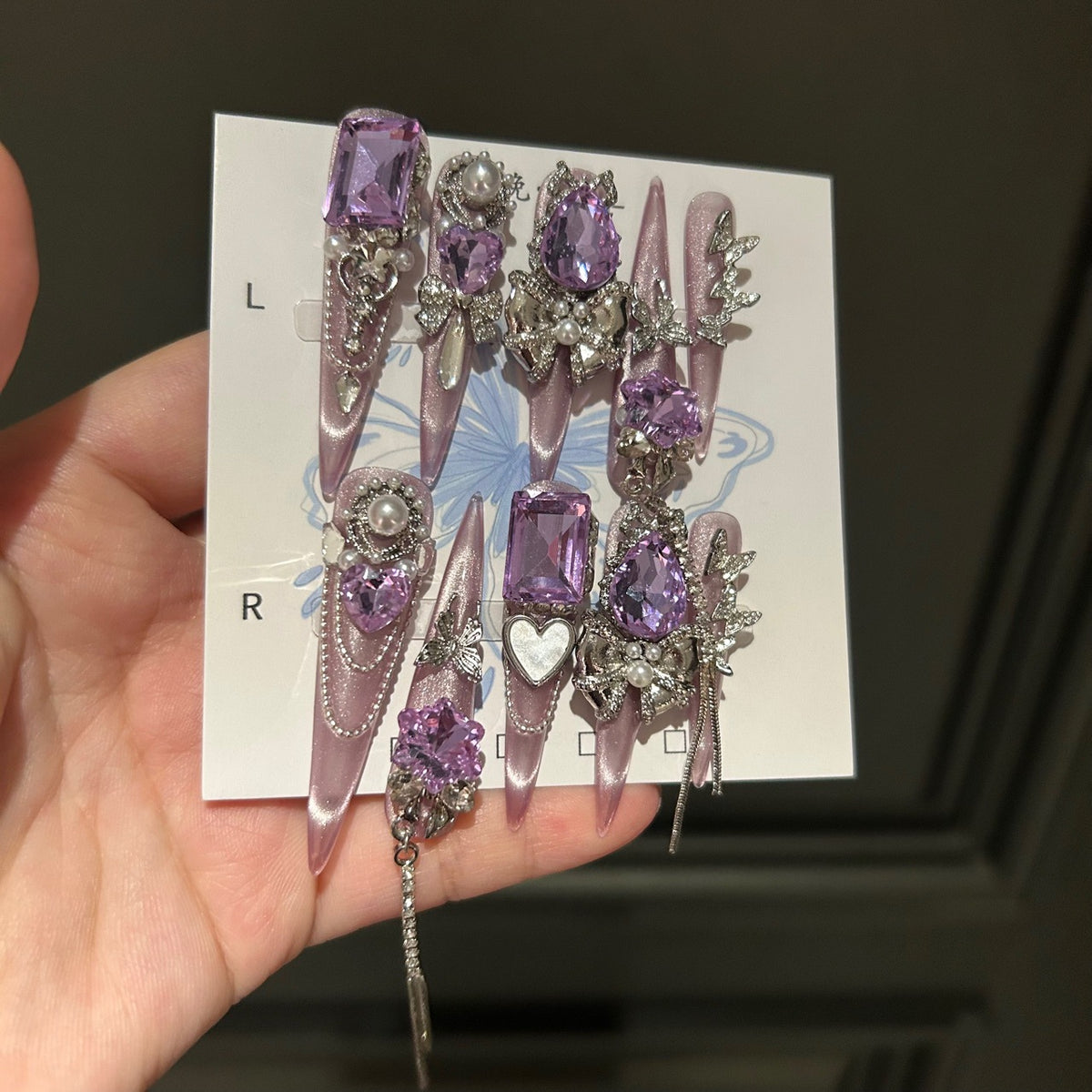 Handmade Milky Pink Metallic Long Stiletto Press On Nails with Large Purple Crystals, Rhinestone Bows, Butterfly Charms, Pearls & Dangling Chains